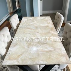 a marble dining table with white chairs around it