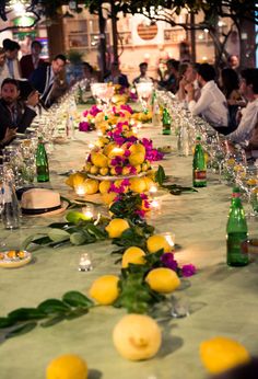 a long table with lemons and flowers on it