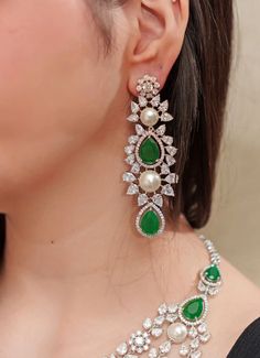 Featuring a white finish exquisite faux diamond layered necklace adorned with green stones. It comes with matching pair of tiered earrings. Perfect to make a statement at a cocktail or reception. Dimensions (Inches) : Necklace - 8 x 4, Earrings- 3.5 x 1 Composition : Faux Diamonds, Green Stones & Mixed Metal Care: Keep away from water and perfume Delivery : 6-8 weeks as the product is hand crafted. For more information and sizes please contact fabiliciousfashion@gmail.com or visit our Copenhagen 4 Earrings, Indian Theme, Stone Necklace Set, Green Stone Necklace, Indian Wedding Wear, Green Stones, Layered Necklace, Traditional Indian, Exquisite Jewelry