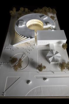 an architectural model of a building with trees and bushes on the ground next to it