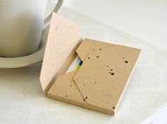 an open book sitting on top of a table next to a cup and saucer