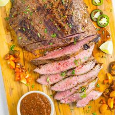 sliced steak on a cutting board with salsa and peppers