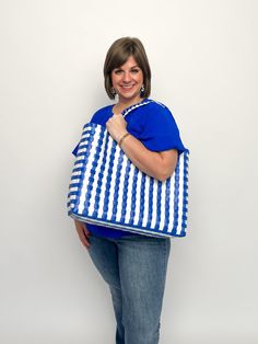 Add some serious sass to your beach game with our Summer Tote Bags. With two color options, this woven bag is the perfect accessory for a day by the water. Stay stylish and organized while carrying all your beach essentials. (No more losing your sunglasses in the sand!) Hot pink, clear, & aruba blue Blue & white Free shipping over $100. Reusable Summer Bag, Blue Plastic Beach Bag, Blue Plastic Beach Bags, Casual Blue Packable Beach Bag, Blue Tote Bag For Beach, Blue Summer Packable Bag, Blue Plastic Tote Bag, Summer Travel Beach Bag Made Of Plastic, Blue Recyclable Beach Bag For Summer