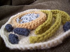 there is a crocheted dishcloth with blue and yellow yarns on it