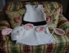 a chair with some bunny ears on it and a white sheep pillow in the back