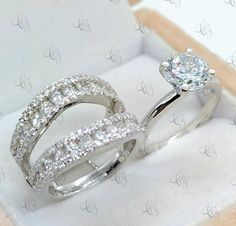 two wedding rings in a box with diamonds on the inside and outside, one is white gold