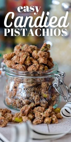 a glass jar filled with candied pistachios on top of a table