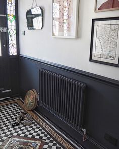 a black and white tiled floor with a radiator in the corner next to it