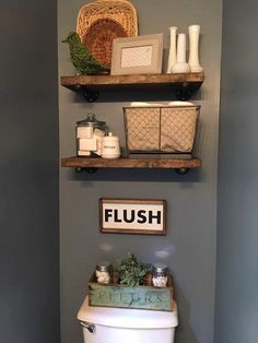 a toilet in a bathroom with shelves above it and other items on top of the toilet