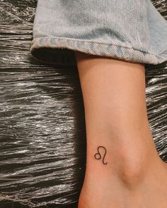 a woman's foot with a small tattoo on the left side of her leg