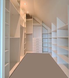 an empty white closet with shelves and drawers on the wall next to carpeted floor