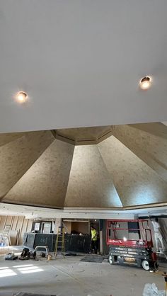 an unfinished room with several lights on the ceiling and construction equipment in the foreground