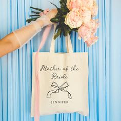 a mother of the bride tote bag with pink flowers on it and a bouquet of carnations