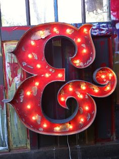 a large neon sign with lights on it's sides in front of a window