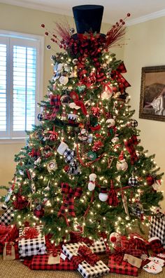 a christmas tree decorated with red and black plaid ribbon