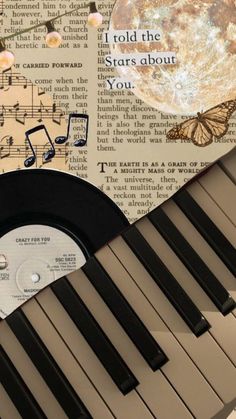 an old record sitting on top of a piano with music notes and butterflies around it