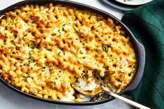 a casserole dish filled with chicken and cheese on top of a white table