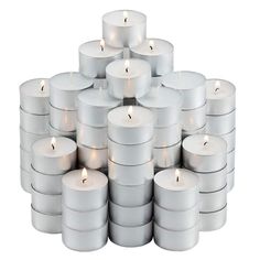 a stack of white candles sitting next to each other in front of a white background