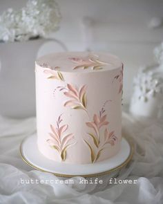 a pink and gold wedding cake with flowers on it