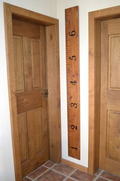 two wooden doors and a ruler on the wall next to each other in a room