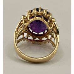 This is part of Chairish’s Fine Jewelry assortment.  14k yellow gold cocktail ring featuring a deep purple/red/blue oval amethyst, encircled by 16 small diamonds.  Ring Size: 6 in. Stone: 16.42 x 12.40 x 8.7 mm Ring Weight: 6.7 grams  If you would like more information, please contact me via email, mrboult@gmail.com. Oval Amethyst Ring With Gemstone Accents For Formal Occasions, Gold Amethyst Ring With Halo Setting, Gold Oval Amethyst Ring With Accent Stones, Gold Amethyst Ring With Gemstone Accents, Oval Amethyst Ring With Gemstone Accents, Formal Oval Birthstone Ring With Gemstone Accents, Classic Oval Amethyst Ring With Halo Setting, Oval Amethyst Ring In Halo Setting Yellow Gold, Collectible Oval Rings With Gemstone Accents