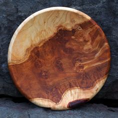 a wooden plate sitting on top of a rock