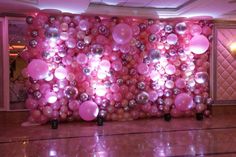 the balloon wall is decorated with pink and silver balloons