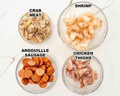 four glass bowls with different types of food in them on a white counter top, labeled shrimp, crab meat, and chicken sausage