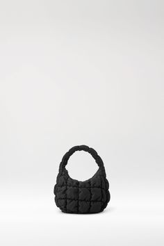 The quilted bag is one of our most sought-after styles, and this shrunken-down version is the perfect size to take you from daytime into evening. Crafted from recycled polyester, it has a pillowy, cloud-like texture, a top handle and a secure zip closure so you can keep your essentials close to hand.- Cotton-canvas lining100% Recycled Polyester, Lining: 50% Cotton, 50% Recycled CottonHeight: 14cm , Width: 17cm, Depth: 6.5cm Black Quilted Evening Bag, Quilted Nylon Top Handle Bag, Quilted Tote Bag For Evening, Quilted Tote Shoulder Bag For Evening, Quilted Evening Shoulder Tote Bag, Black Quilted Top Handle Shoulder Bag, Evening Quilted Tote Shoulder Bag, Black Quilted Top Handle Bag, Black Quilted Shoulder Bag With Double Handle