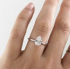 a woman's hand with a ring on it and a diamond in the middle