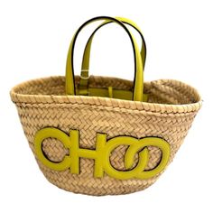 Elevate your summer style with the Jimmy Choo Logo Crossbody Tote Bag, crafted from natural raffia with citron yellow leather trim. This chic tote features the iconic Jimmy Choo logo detailing, two leather handles, and a convenient tie closure. Its interior is unlined keeping the natural raffia consistent throughout the bag and includes one pocket for organization.  Perfect for any occasion, this bag combines luxury with practicality. Add a touch of sophistication to your look with Jimmy Choo's Designer Summer Straw Bucket Bag, Designer Summer Bags With Intrecciato Weave, Designer Bags With Intrecciato Weave For Summer, Designer Rectangular Straw Bag For Summer, Designer Straw Bag With Handles For Vacation, Designer Natural Straw Bag For Summer, Designer Summer Straw Bag With Top Handle, Designer Beach Straw Bag With Handles, Designer Summer Straw Shopping Bag