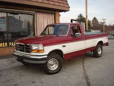 a red and white truck parked in front of a store