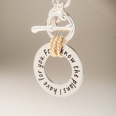 a silver and gold necklace with words on it