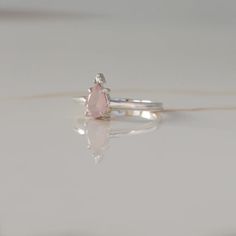 A ring that reminds you of the queen that you are? A pear-shaped Rose Quartz topped with a round Moissanite is giving us full-on royal vibes and we are loving it. A little treat-yourself gift never hurt nobody! Details: Center stone Gemstone: Rose Quartz Stone Shape: Pear Measurements: approx. 7x5mm Side stones Gemston Pear-shaped Rose Cut Diamond Rings For Proposal, Pear Shaped Rose Cut Diamond Ring For Proposal, Pear-shaped Rose Cut Diamond Proposal Ring, Teardrop Rose Cut Diamond Promise Ring, Pink Pear-shaped Gemstone Rings, Teardrop Diamond Ring For Proposal, Rose Gold Teardrop Ring For Proposal, Teardrop Diamond Ring With Gemstone As Gift, Teardrop Diamond Ring With Gemstone For Gifts