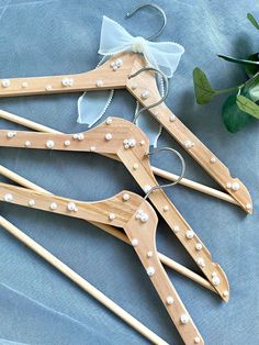 three wooden clothes pins with pearls on them and a flower in the middle, sitting next to each other