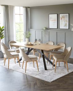 a dining room table with six chairs and a rug on the floor in front of it