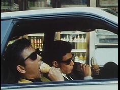 two men sitting in a car eating ice cream