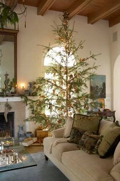 a living room filled with furniture and a christmas tree in the middle of the room