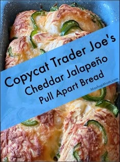 a close up of food in a pan with a blue sign over it that says copycat trader joe's cheddar jalapeno pull apart bread