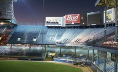 an empty baseball stadium at night with bud light on the bleachers and billboards