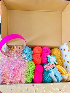 an open box filled with lots of different colored yarns and sprinkles