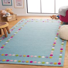 a child's room with a blue rug and teddy bear on the floor in front of it