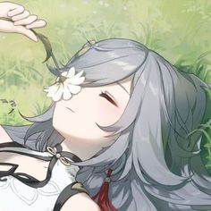 a woman with long gray hair and a flower in her hair is laying on the ground