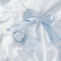 a white blanket with a blue bow and some cards on it