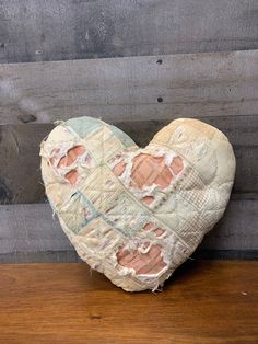 a heart - shaped piece of fabric with holes in the middle on a wooden surface