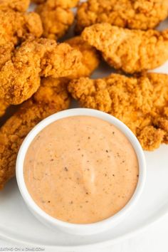 chicken nuggets and dipping sauce on a white plate