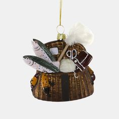 a christmas ornament hanging from a rope with fishing related items in the basket