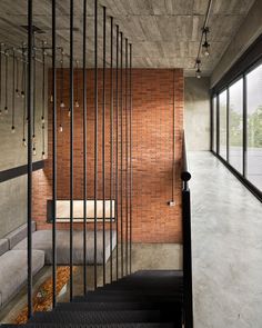 the stairs lead up to the bedroom in this modern house with brick walls and steel railings