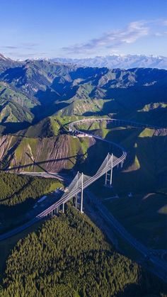 an aerial view of a bridge in the mountains