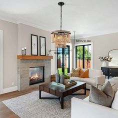 a living room filled with furniture and a fire place in the middle of it's wall